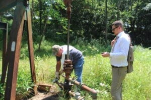 Marietta Bob Wilson, an oil producer in Washington County (left) reads the pressure of an injection well in Marietta while Ohio state Rep. Tristan Rader, D-Lakewood looks on. (Photo by Megan Henry, Ohio Capital Journal).