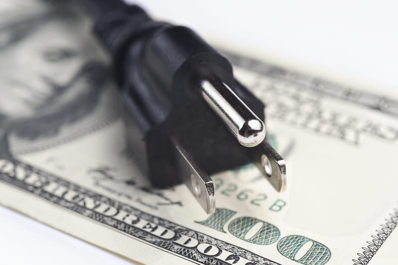 Power cord over U.S. dollar bills. (Photo: choness/iStock)