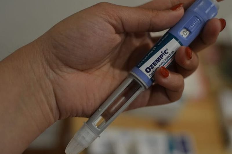 A woman takes out an Ozempic pen. More states are considering dropping GLP-1 drugs from their Medicaid programs. (Photo by Shalina Chatlani/Stateline)