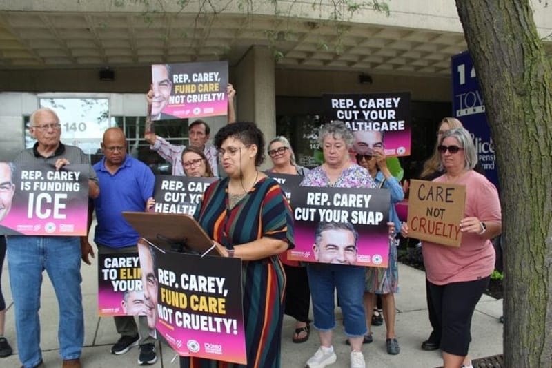 Susan Cavendish discusses how her children rely on services and therapies through Medicaid during a protest outside Ohio Republican U.S. Rep. Mike Carey’s Columbus office. (Photo by Megan Henry, Ohio Capital Journal).