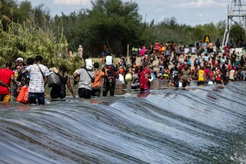 Migrants, many fleeing violence in Haiti, cross the Rio Grande at Del Rio, Texas, in 2021 to buy supplies in Mexico while waiting to claim asylum in the United States. The U.S. Supreme Court is likely to weigh in on a Trump administration policy that allows detention without bond for millions of migrants who illegally crossed a border. (Photo by Jordan Vonderhaar/The Texas Tribune)