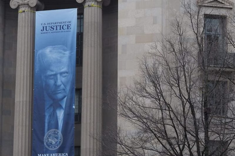 A banner showing President Donald Trump hangs on the Robert F. Kennedy Building of the U.S. Department of Justice on Feb. 20, 2026. (Photo by Shauneen Miranda/States Newsroom)